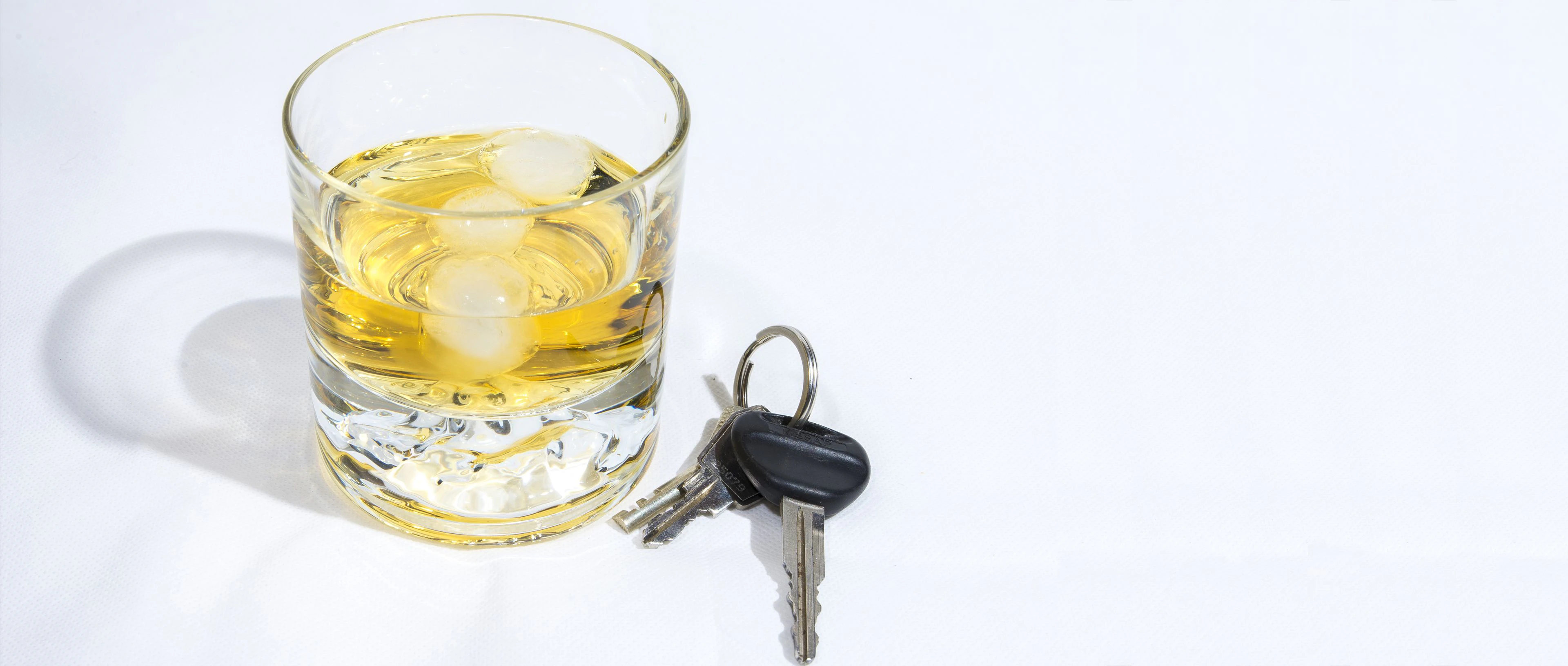 verre d'alcool à côté de clés de voiture