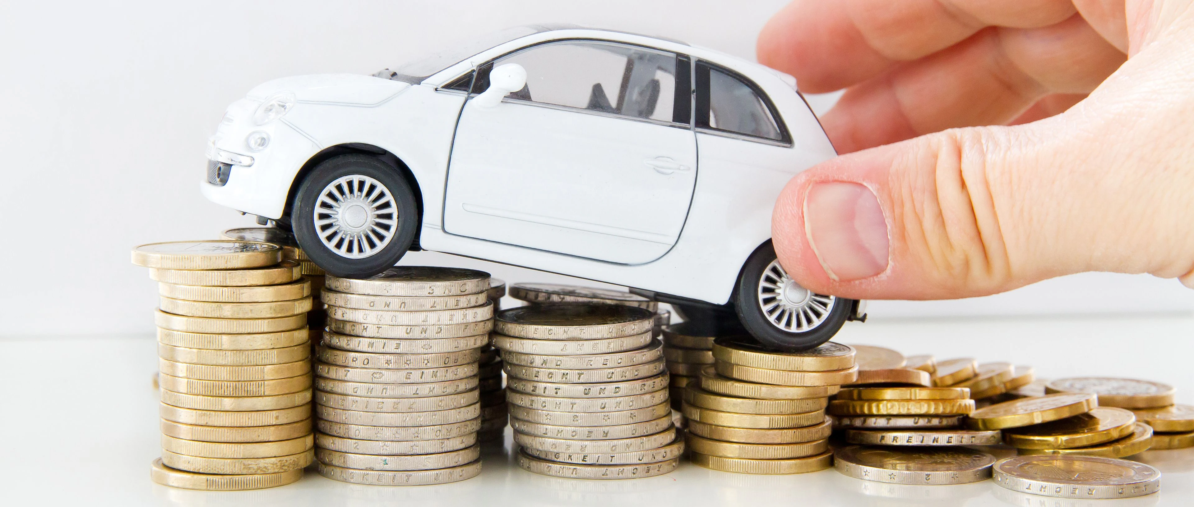voiture miniature qui roule sur de la monnaie