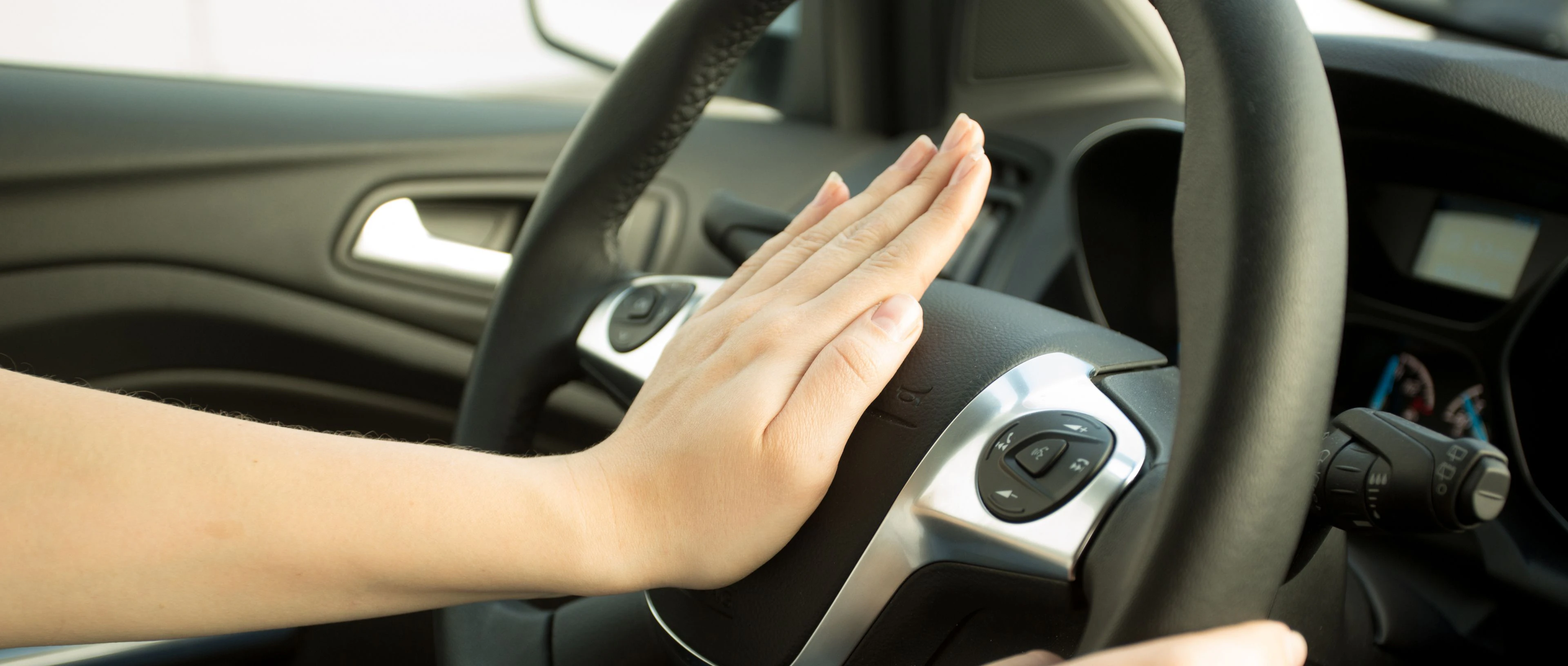 personne qui appuie sur son klaxon de voiture