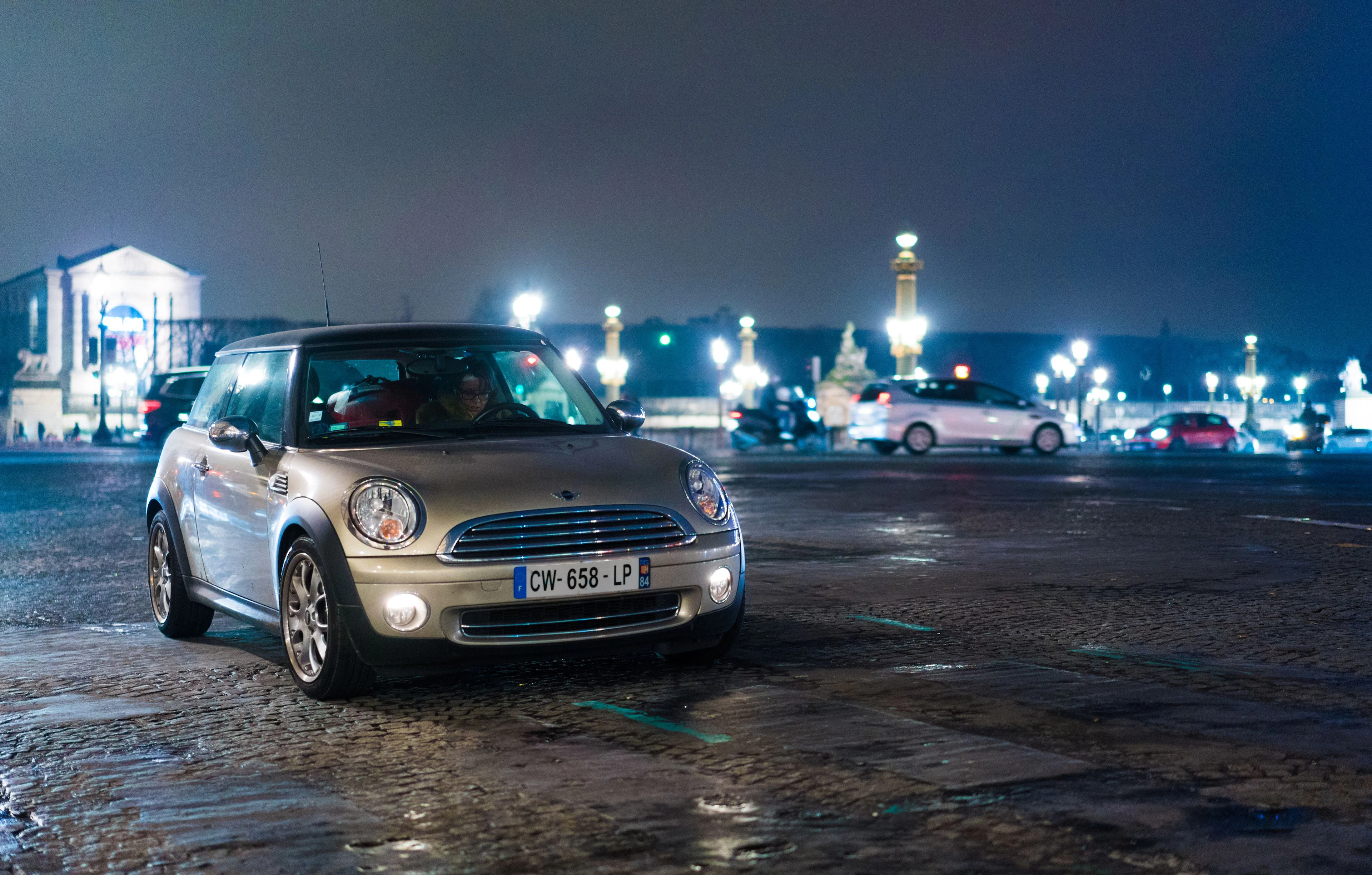 Voiture à l'arrêt sur une grande place de nuit