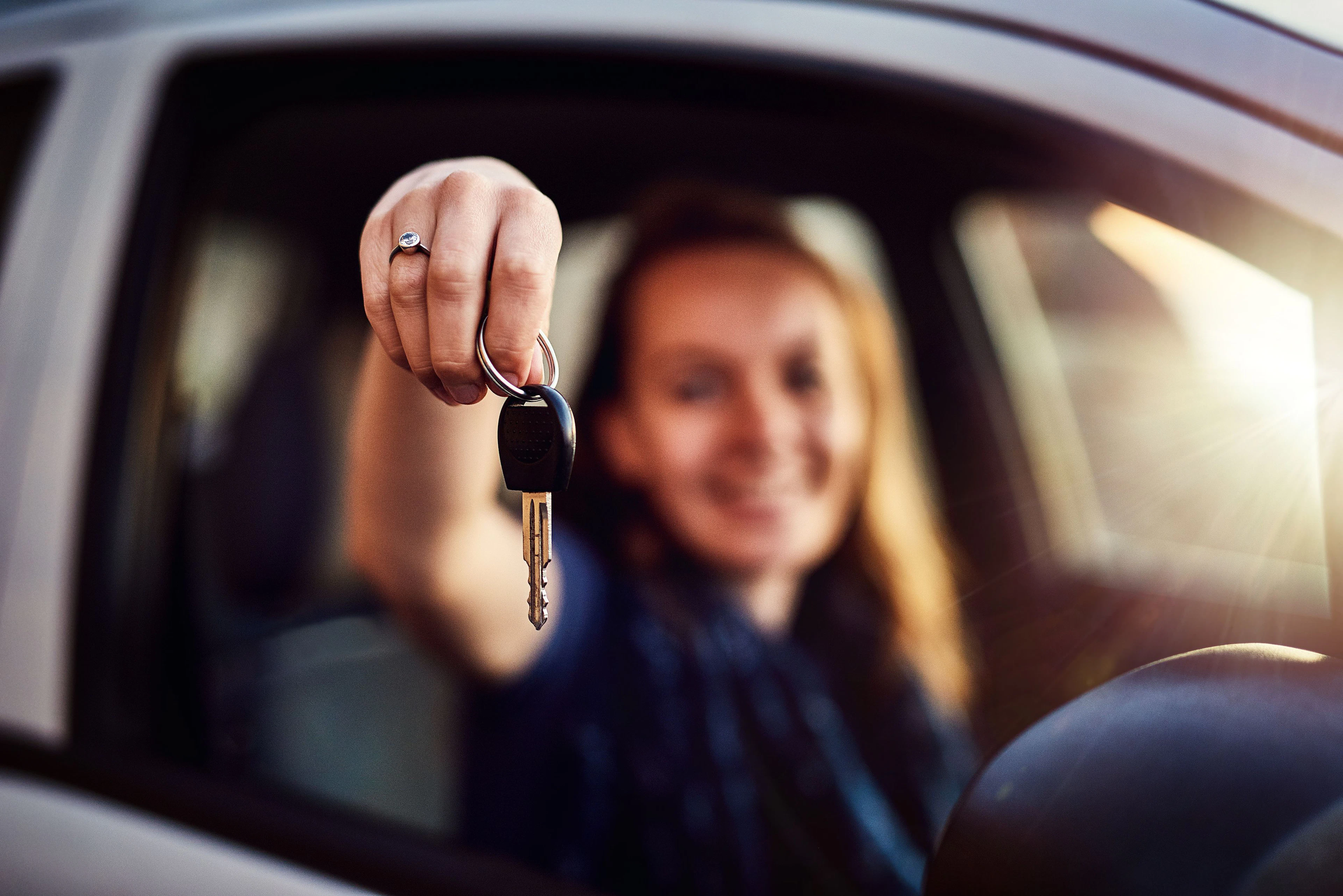 Personne dans une voiture qui tient une clé en main
