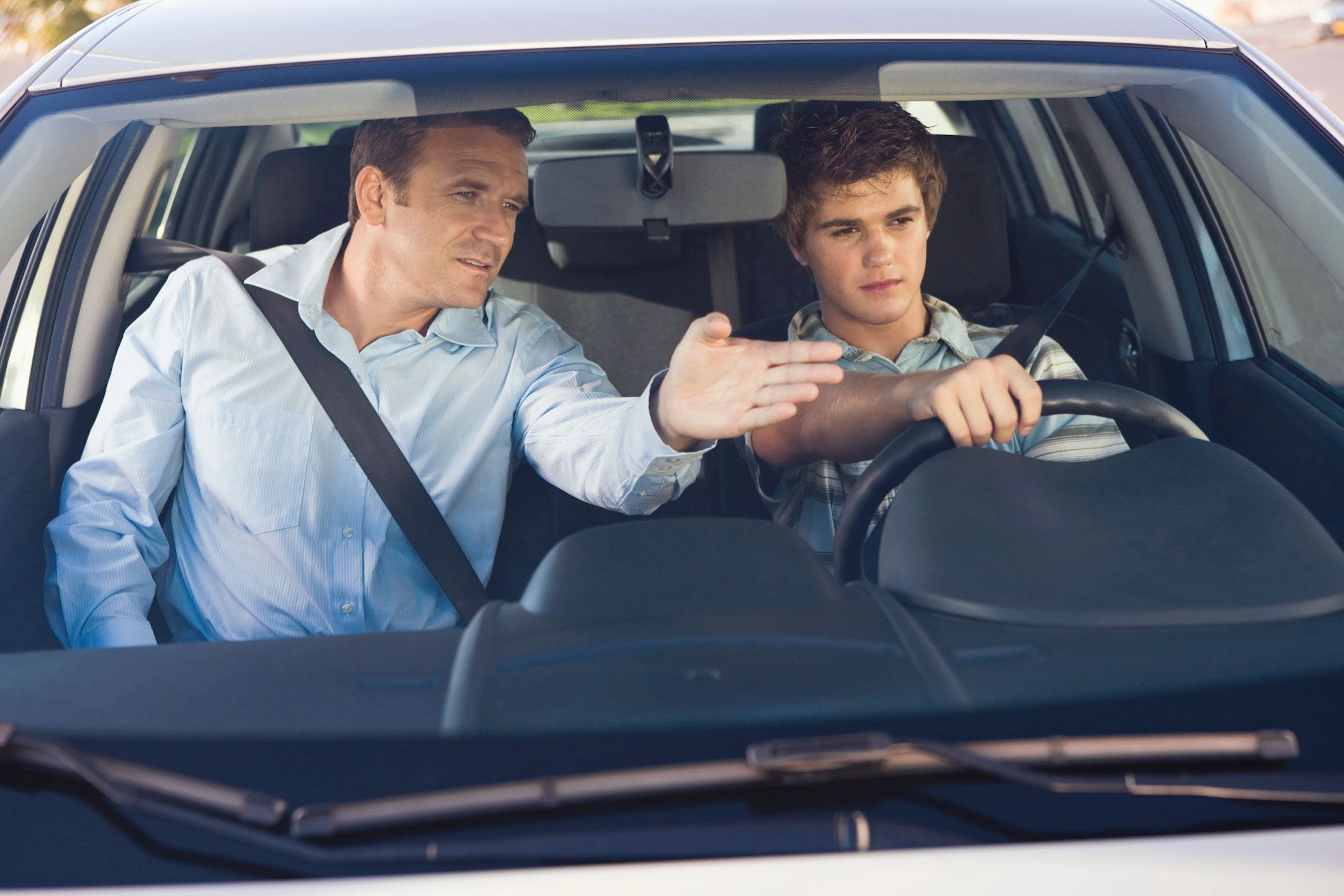 Élève au volant d'une voiture avec son moniteur