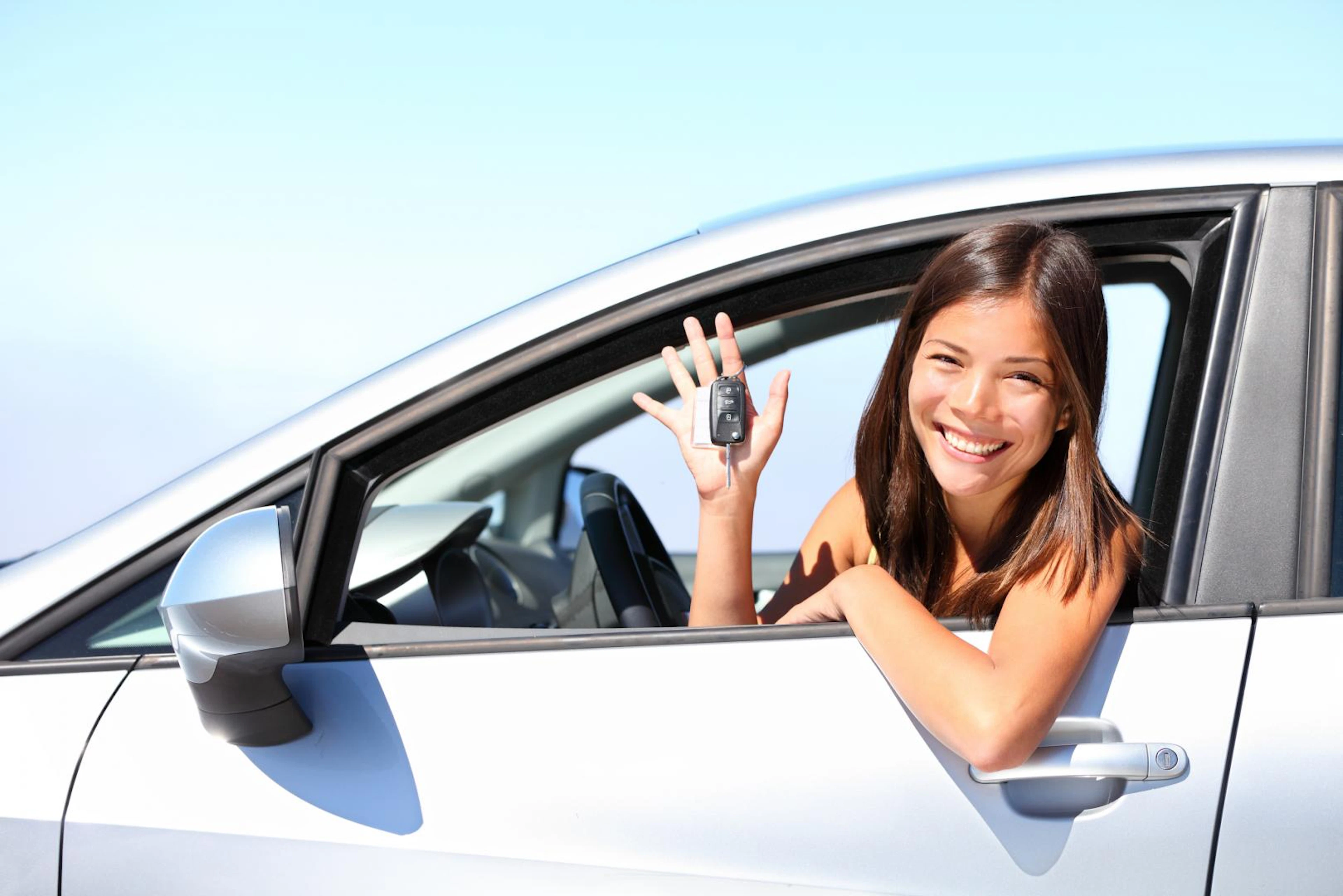 Personne au volant avec une clé de voiture en main 