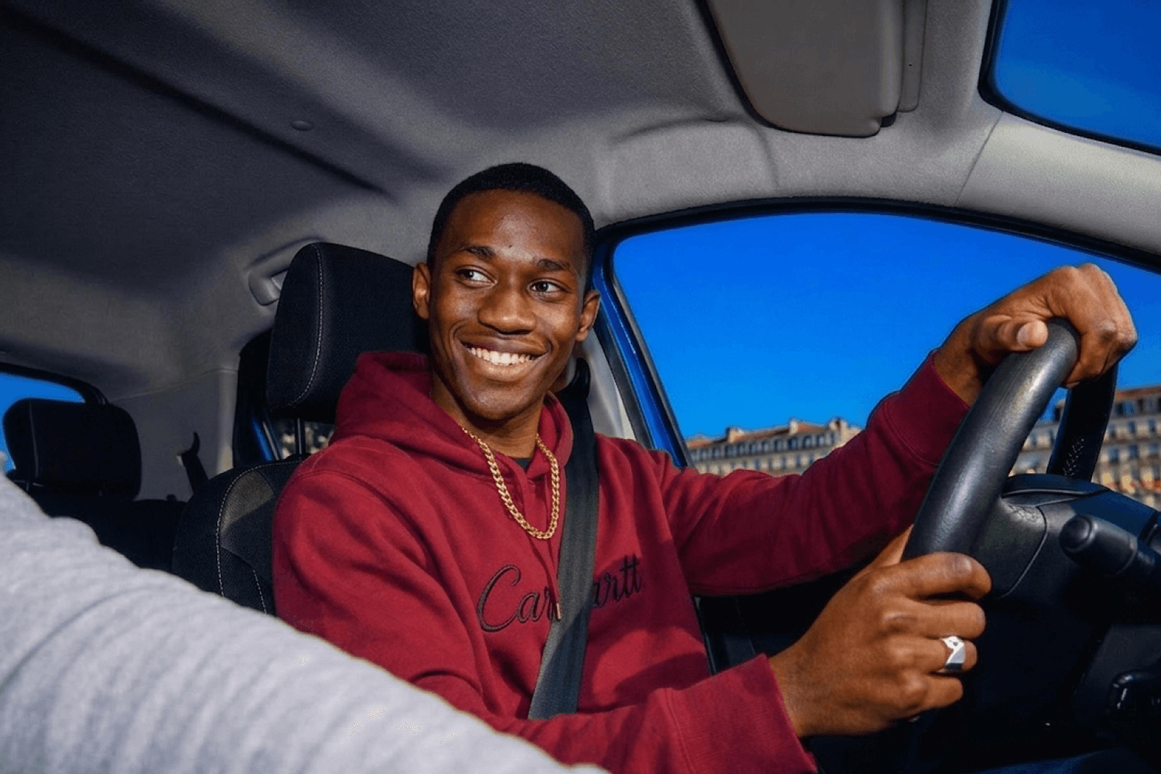 Un élève heureux au volant d’une voiture auto-école