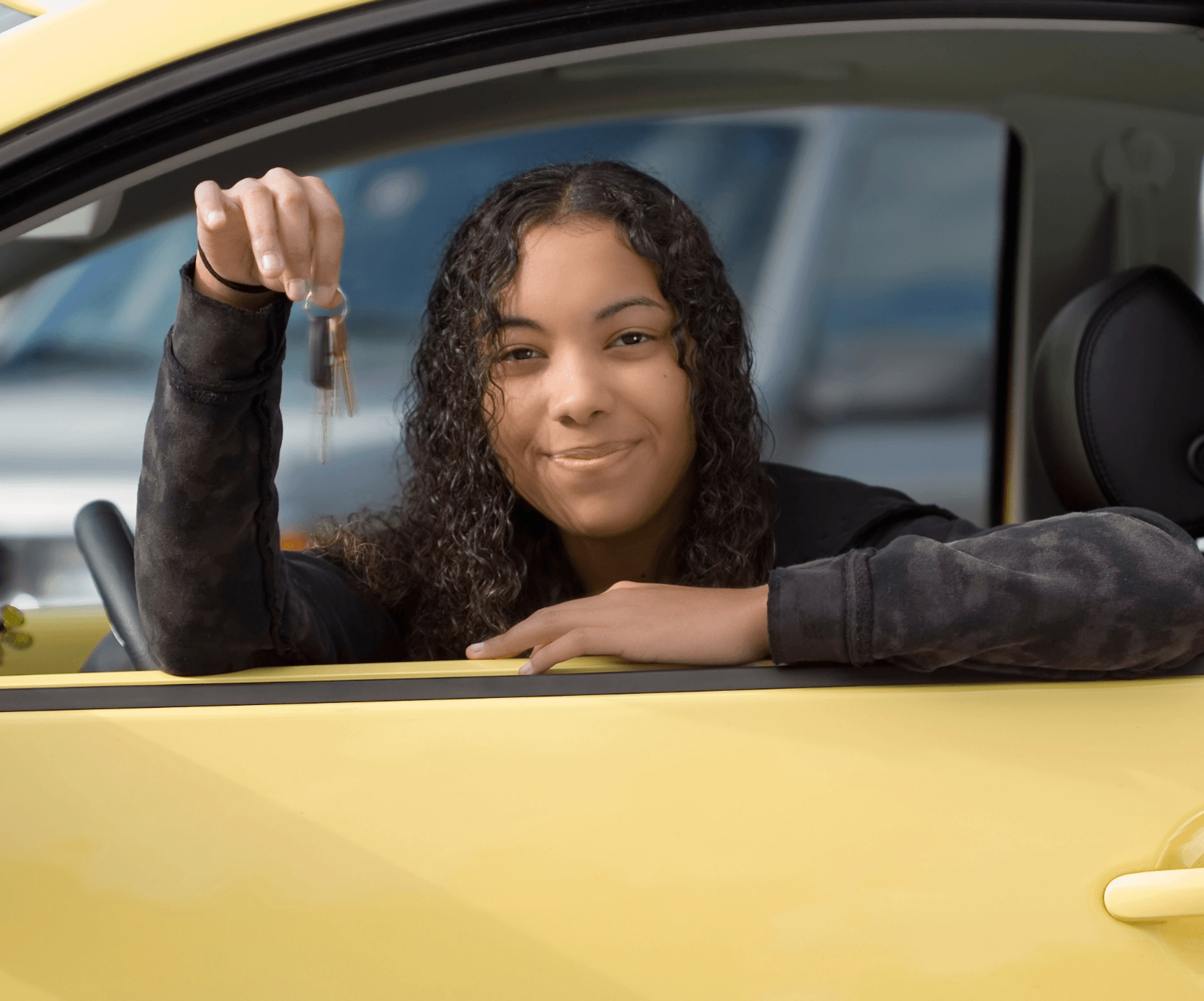 Une jeune fille de 17 ans coté conducteur qui tient dans sa main des clefs 
