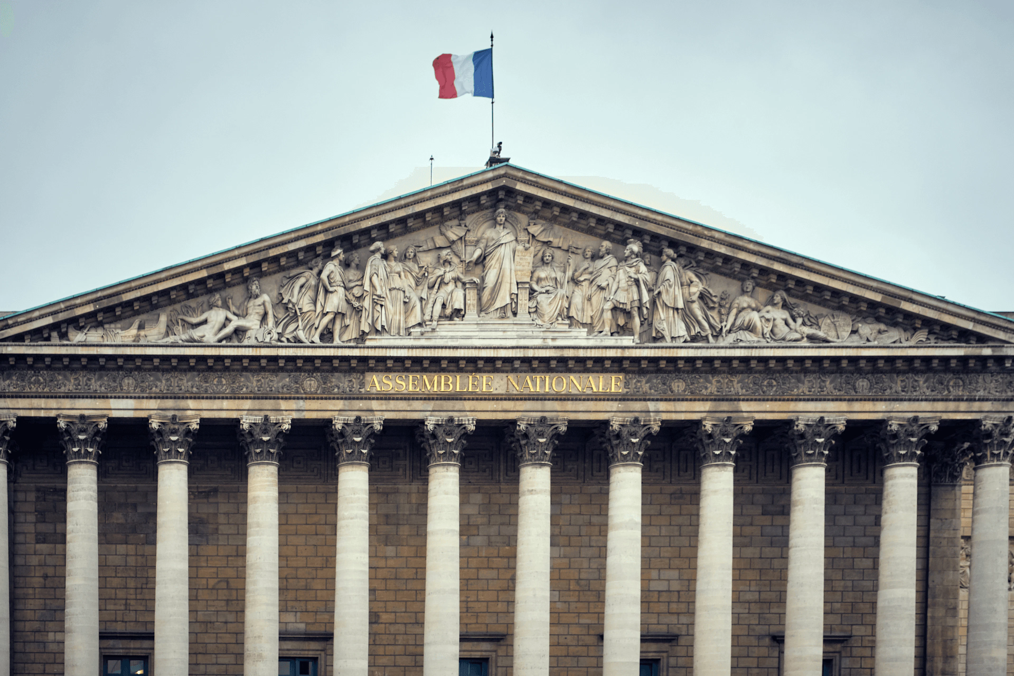 Assemblée nationale à Paris, avec un drapeau français et un ciel bleu 