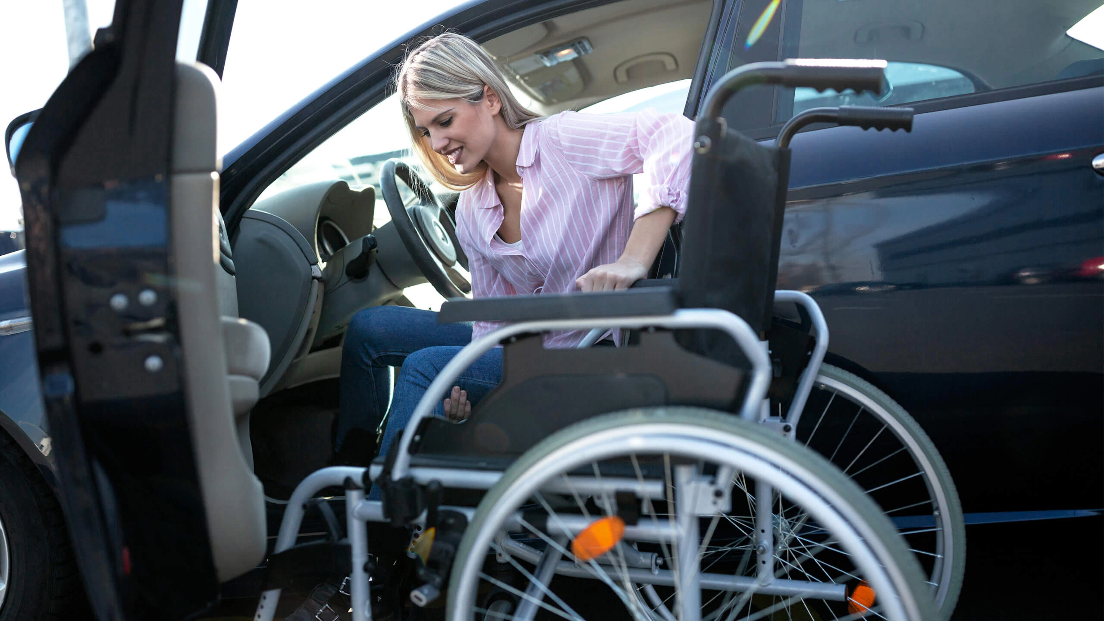 Personne en situation de handicap qui entre dans une voiture 