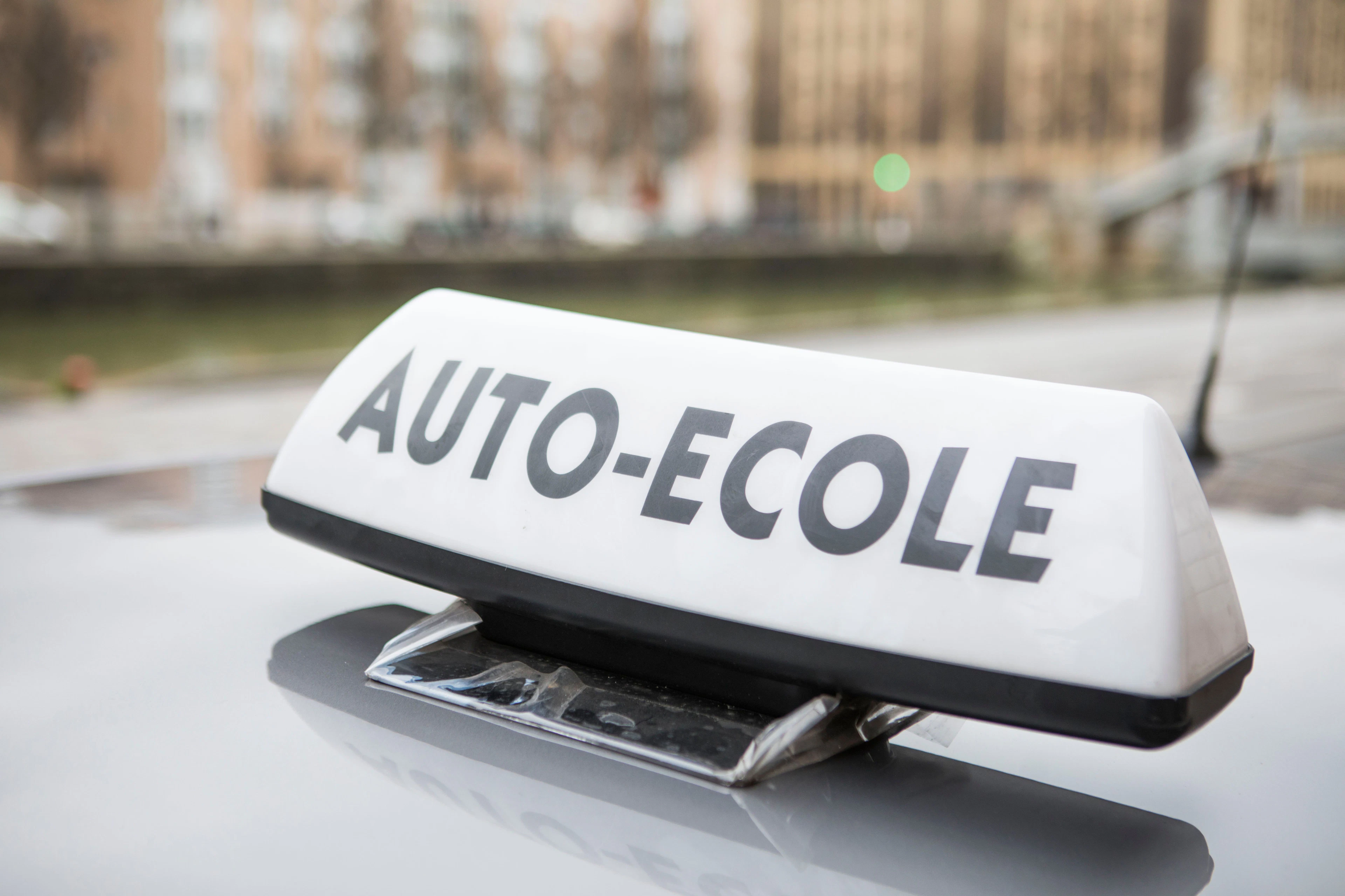 Signe auto-école posé sur le toit d'une voiture 