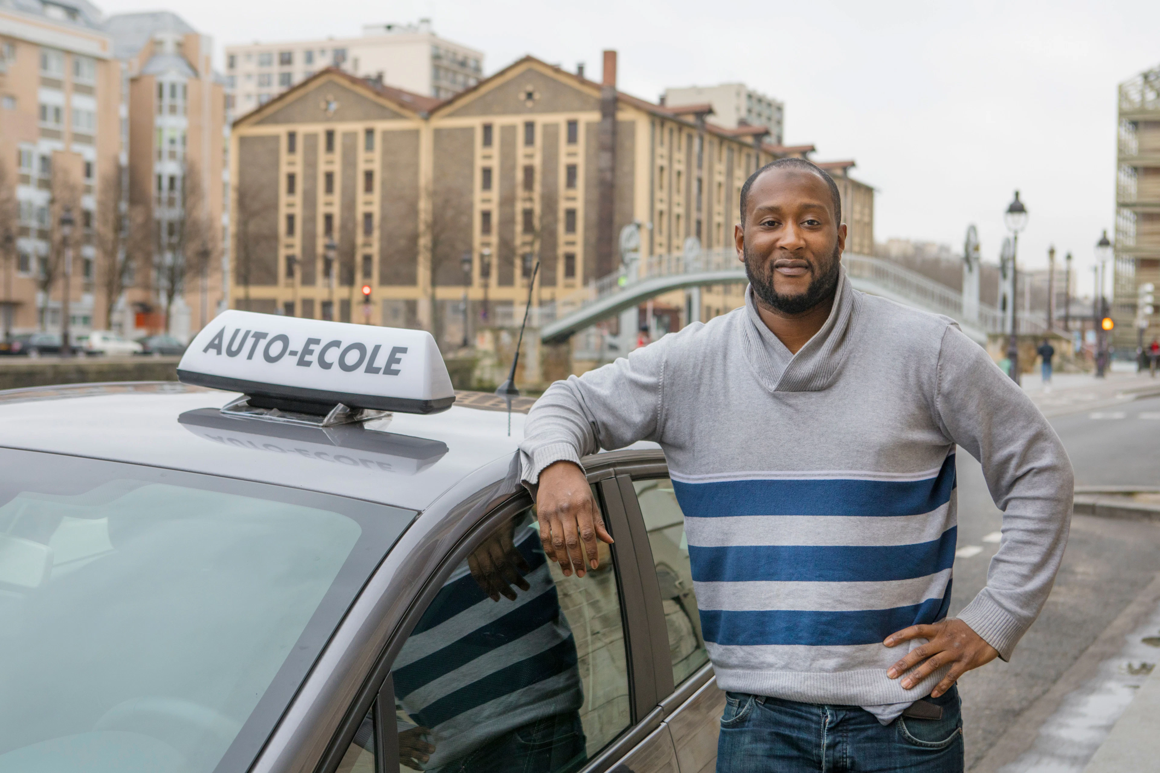 Moniteur debout à côté d'une voiture d'auto-école