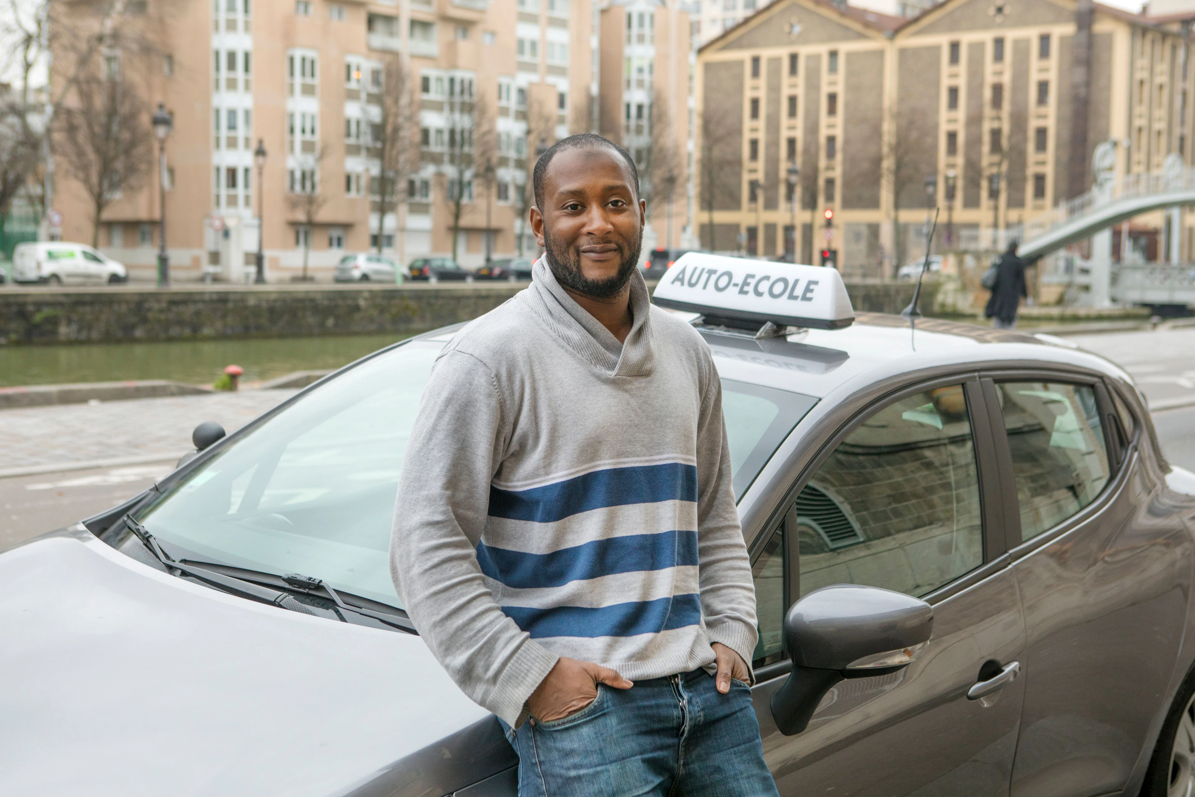 Moniteur debout à côté d'une voiture d'auto-école