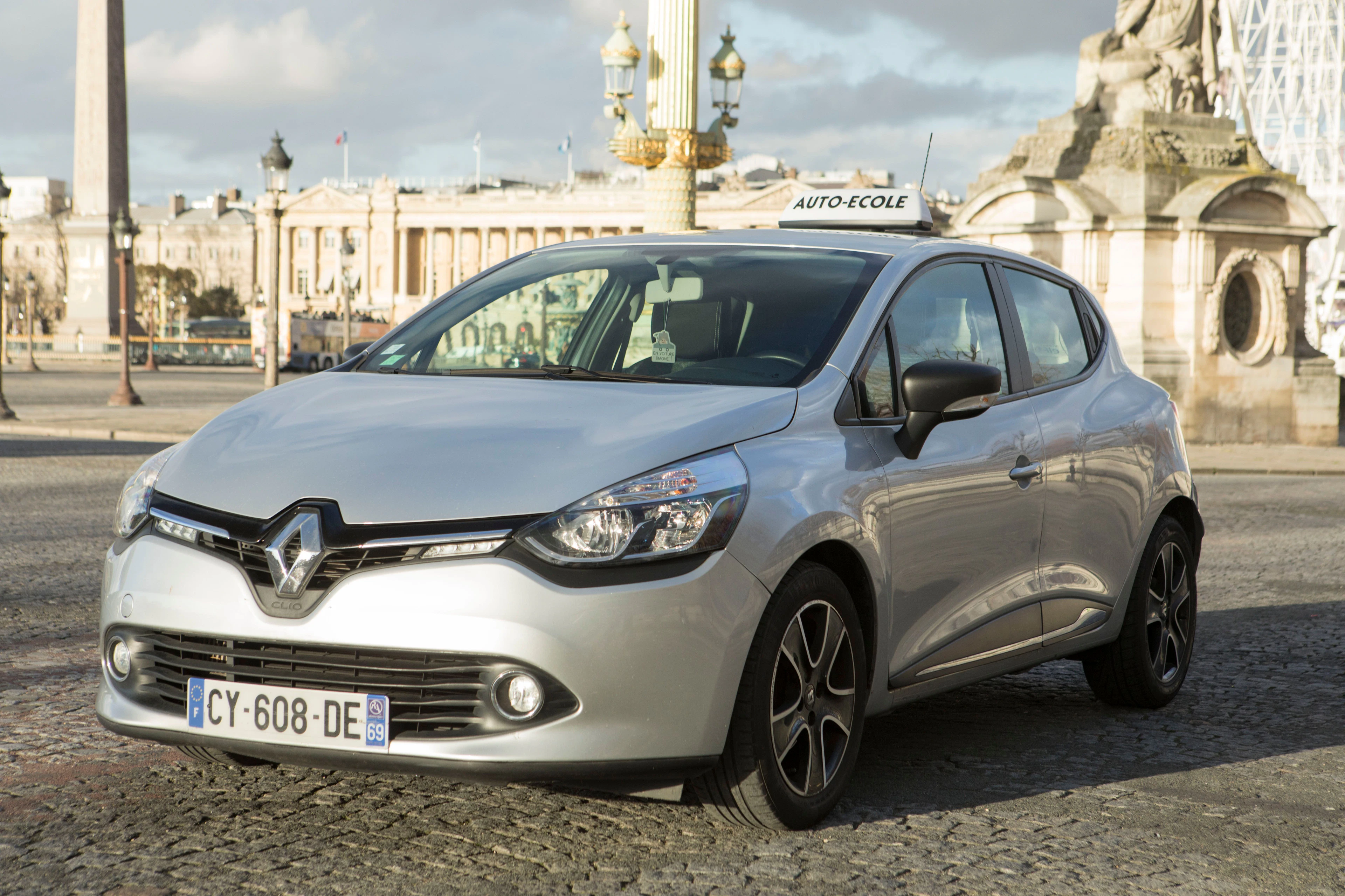 Voiture d'auto-école à l'arrêt sur une grande place