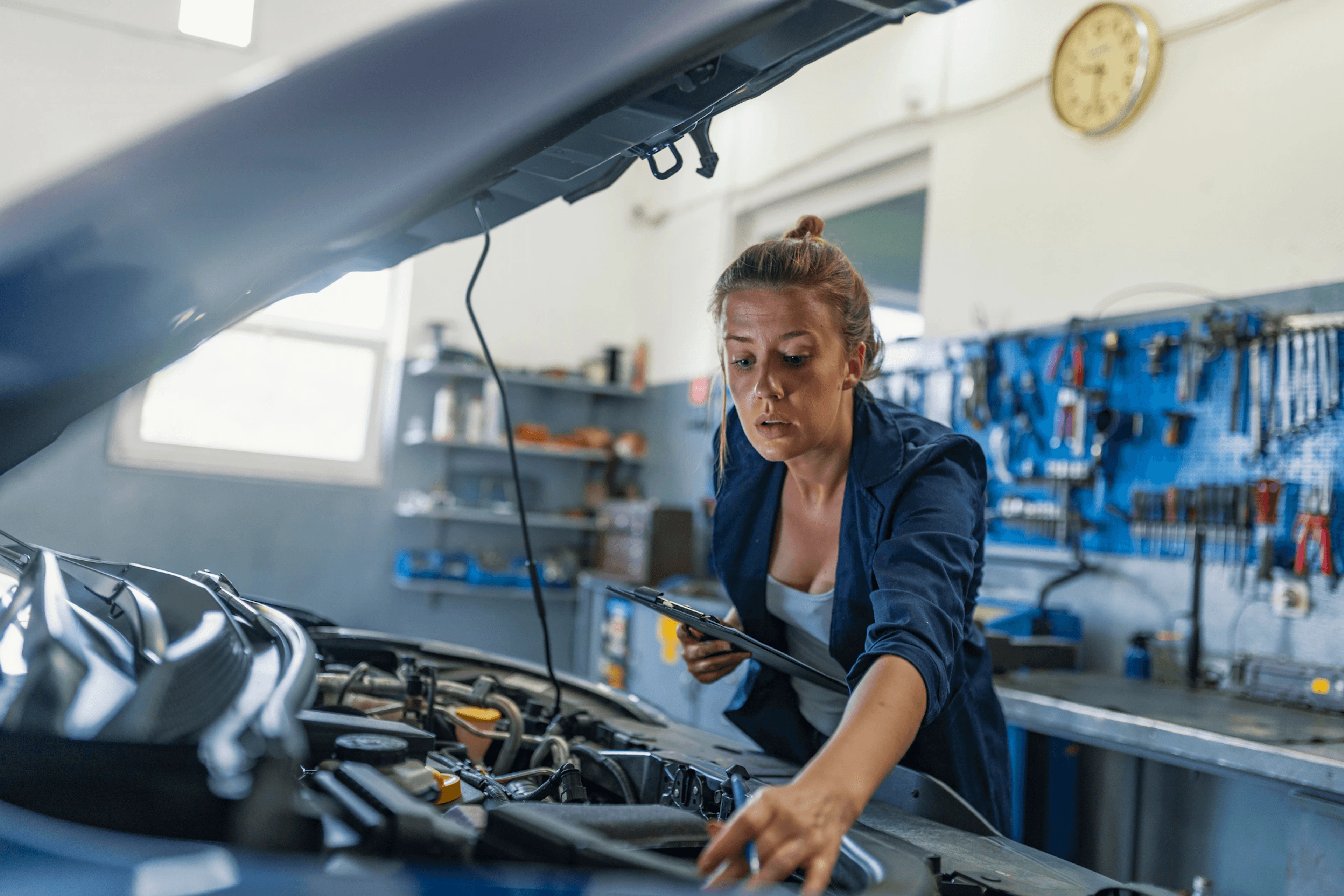 Mécanicienne, qui répare le moteur d'une voiture
