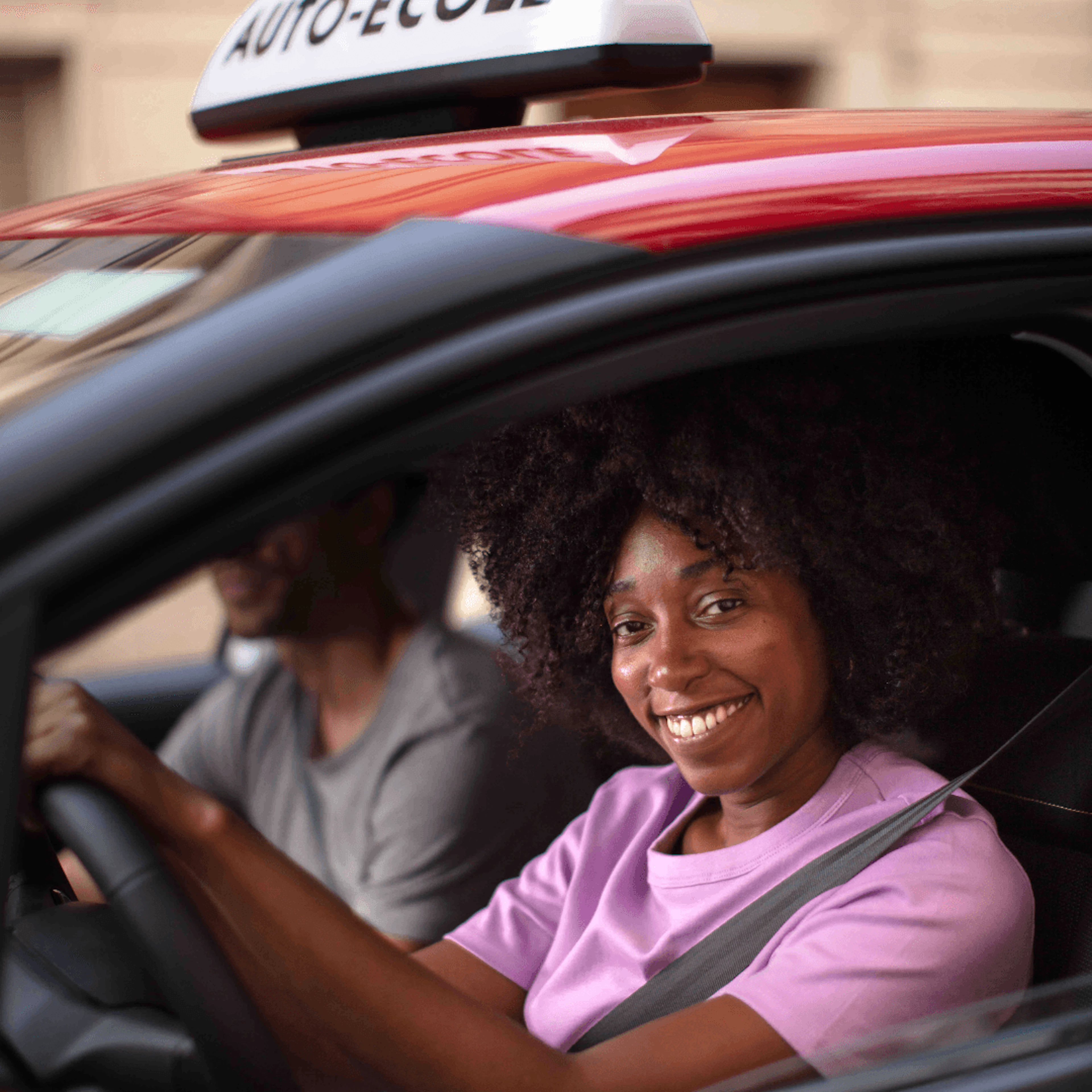 Une élève et son moniteur de conduite lors d'un cours en auto-école