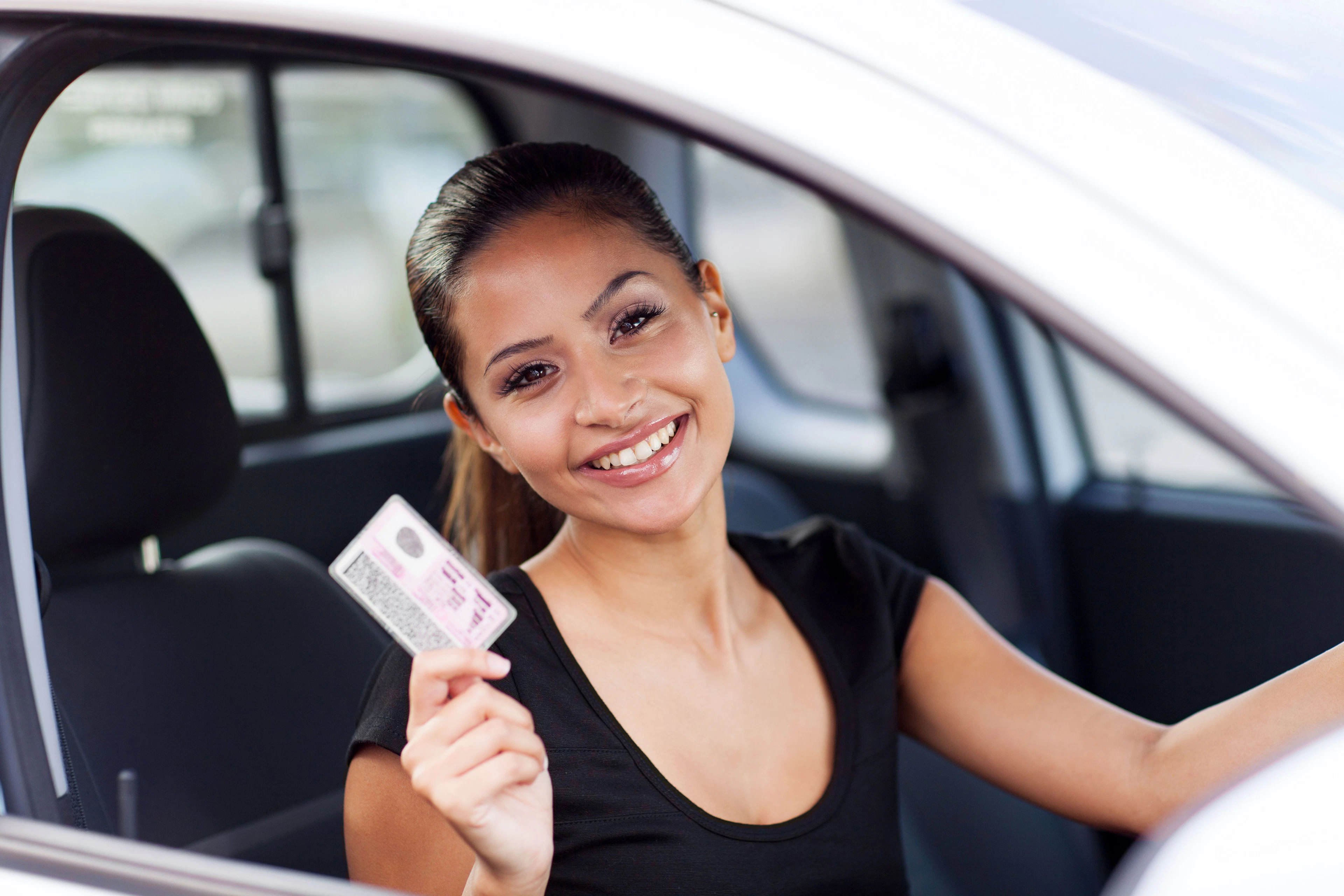Personne en voiture qui montre son permis de conduire 