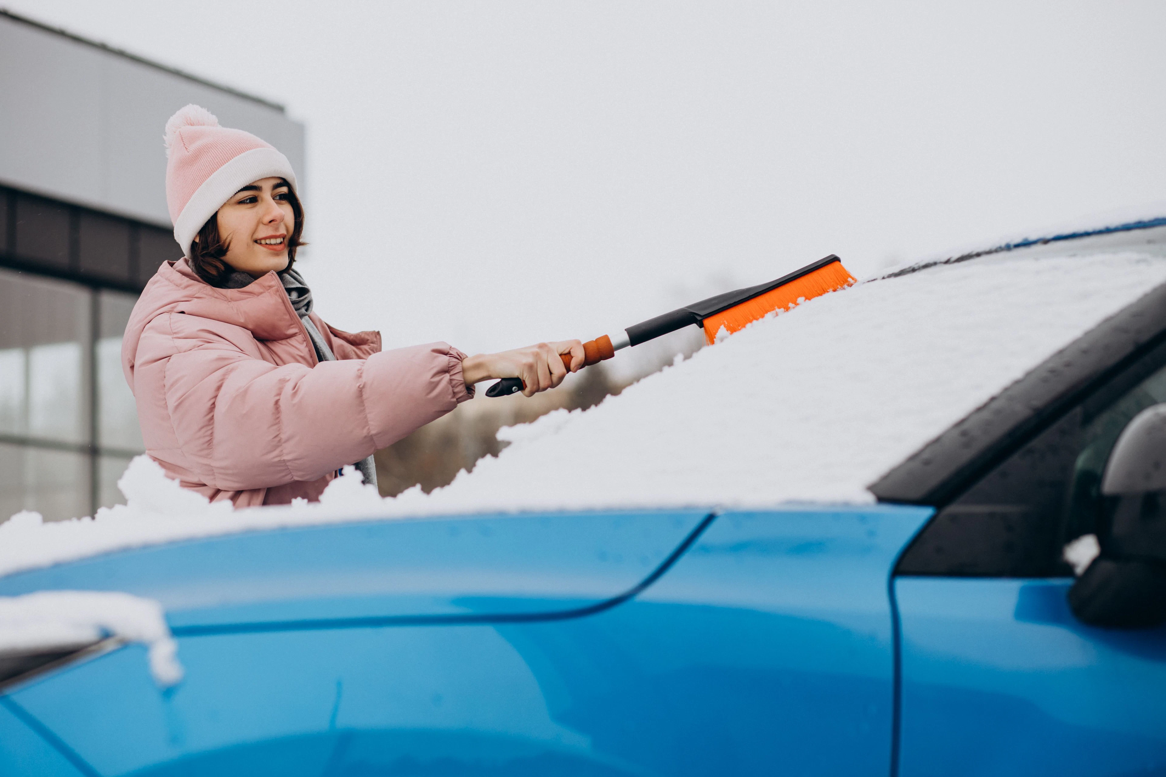 femme qui racle la neige de sa voiture